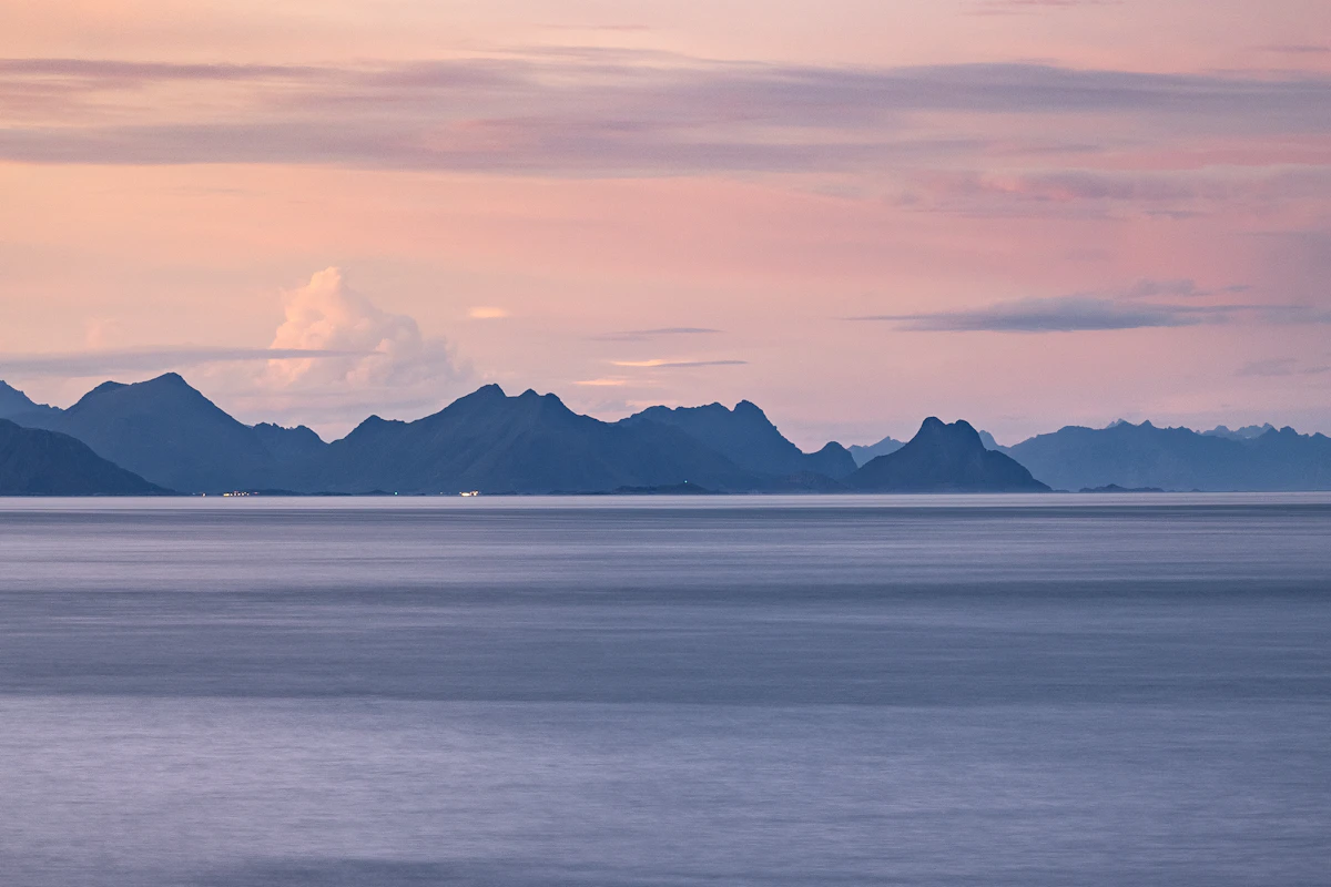Quiet Norwegian water framed by mountains beneath an open sky