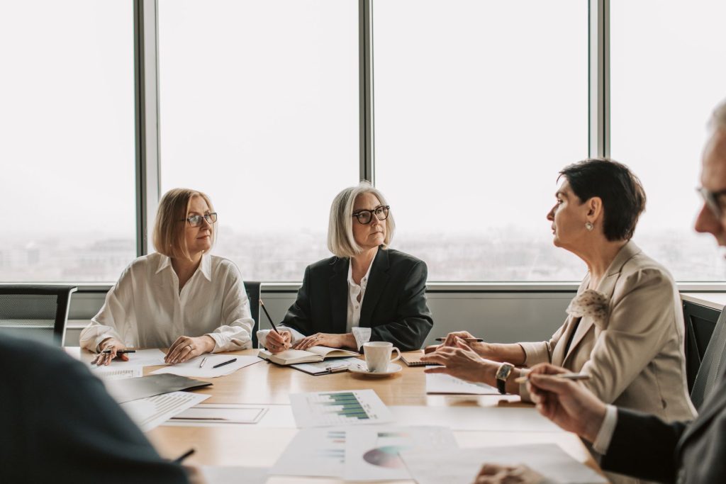 Experienced colleagues listening and discussing documents around a conference table in a modern office.